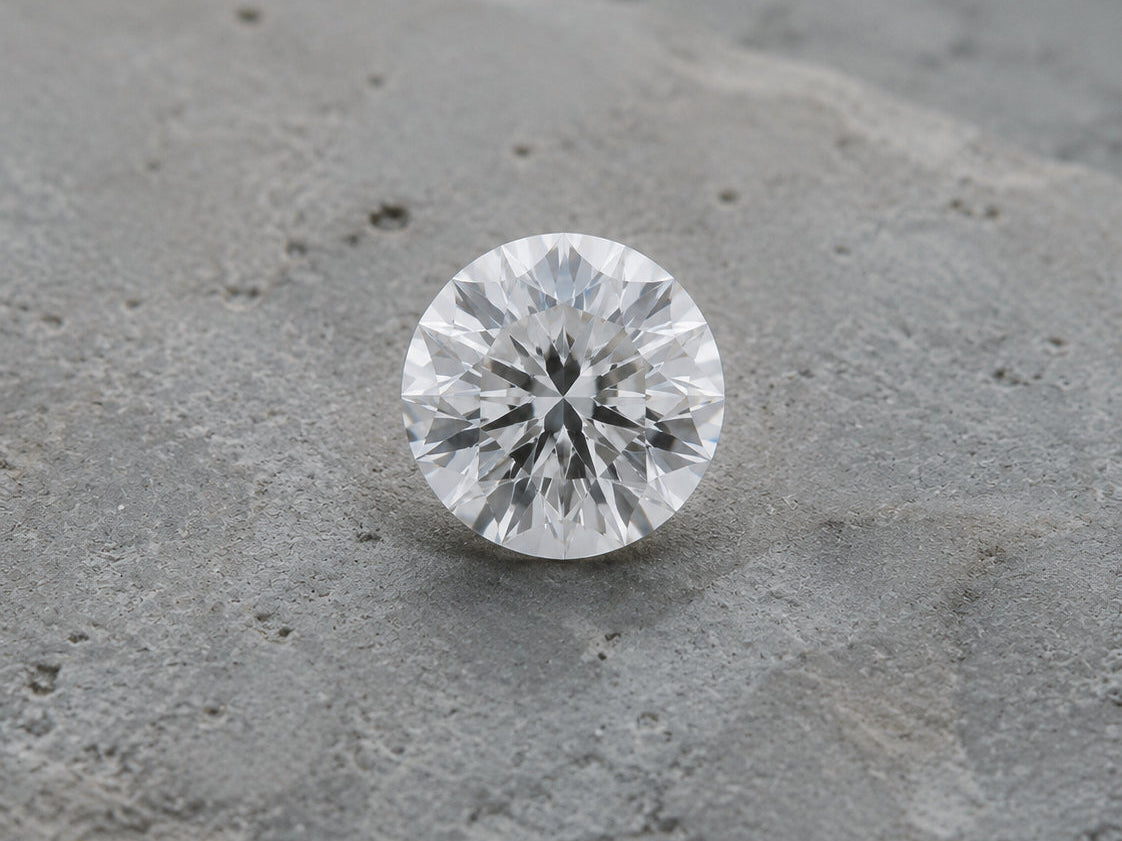 A lab-grown diamond resting on a concrete surface — DHARIN