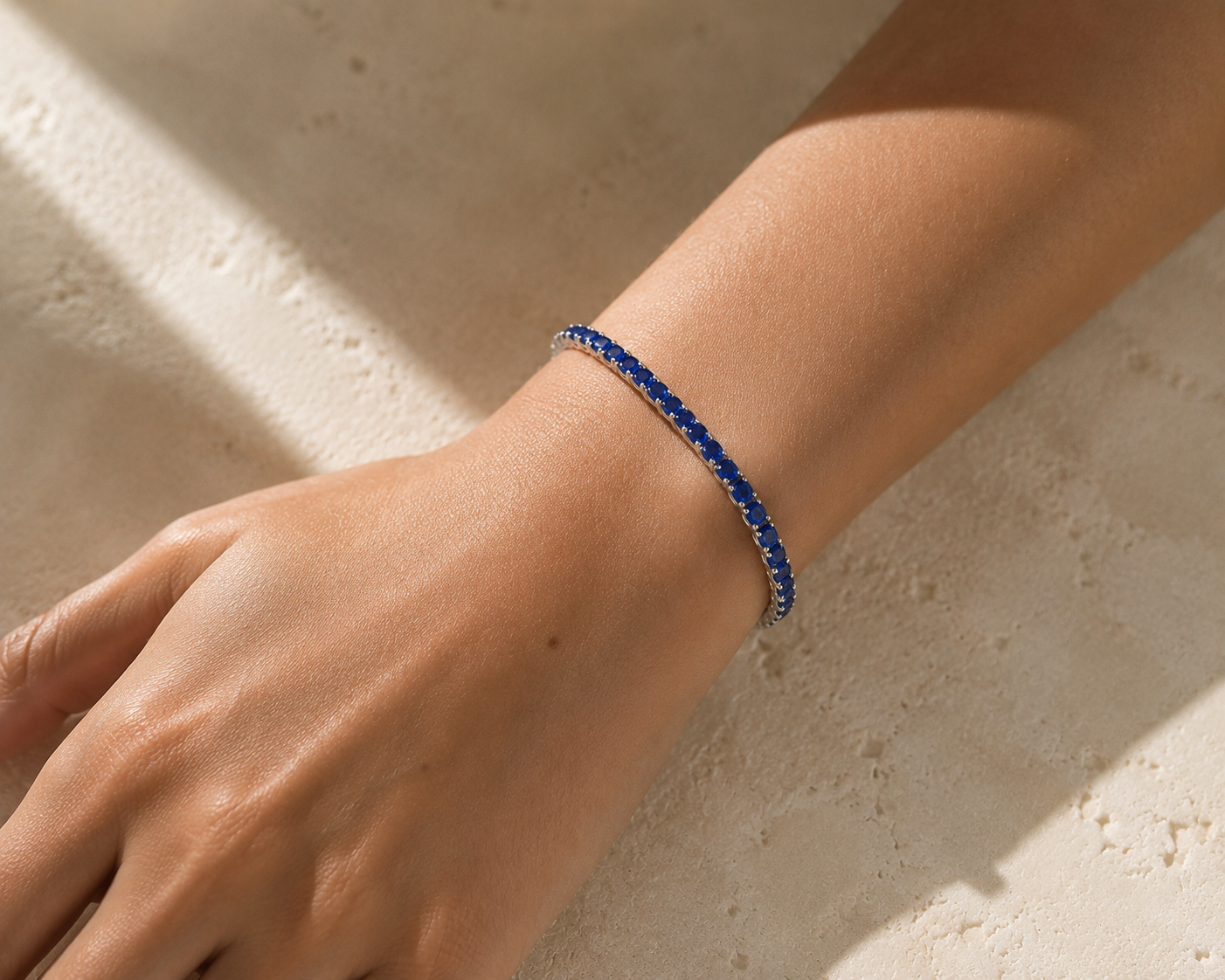 DHARIN Blue Sapphire Tennis Bracelet - 45 degree view, continuous sapphire row, sterling silver