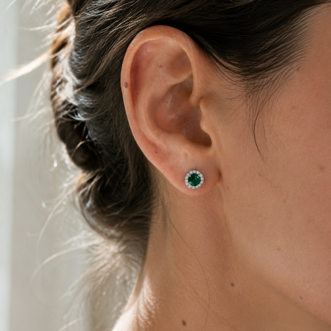 DHARIN Emerald Halo Stud Earrings - ear wearing lifestyle, vivid green emerald on earlobe, quiet luxury